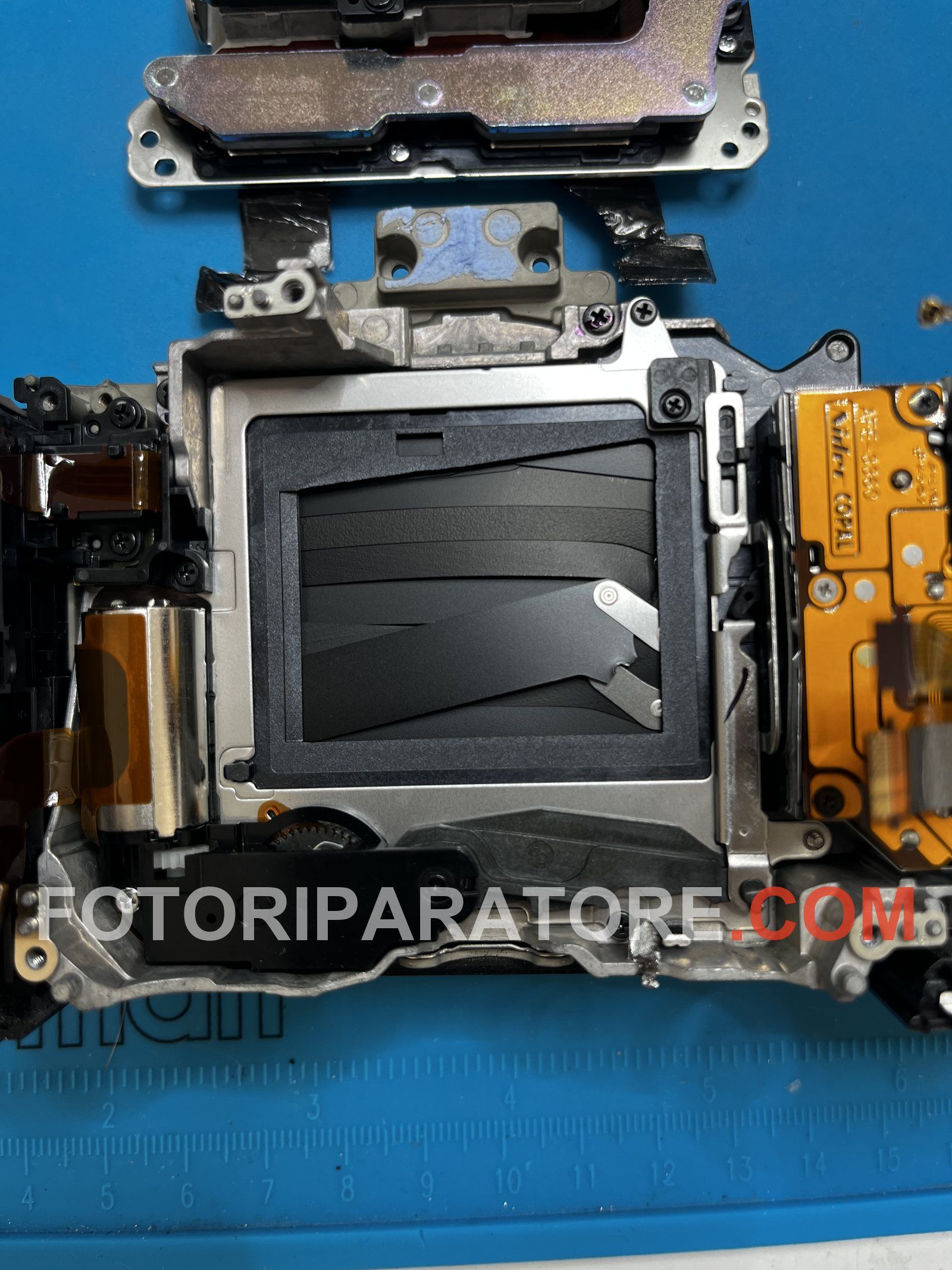 Otturatore rotto della Sony A7 III visto da vicino: lamelle accartocciate e leva di comando deformata